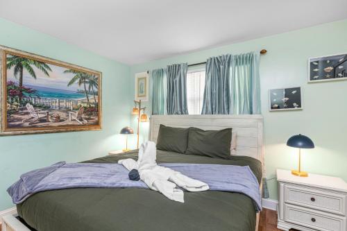 a bedroom with a bed with a towel animal on it at Boho Bungalow in Panama City Beach