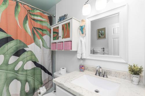 a bathroom with a sink and a mirror at Boho Bungalow in Panama City Beach