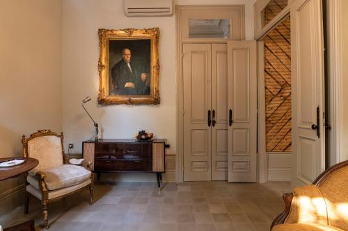 uma sala de estar com um quadro de um homem na parede em Victoria House no Porto