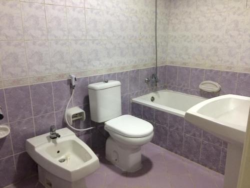 een badkamer met een wit toilet en een wastafel bij COUPLES SIZE PARTITION ROOM near FINANCIAL METRO/DIFC in Dubai