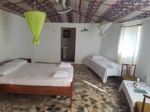 a room with two beds and a table and a ceiling at Camping Sitaba Lodge in Georgetown