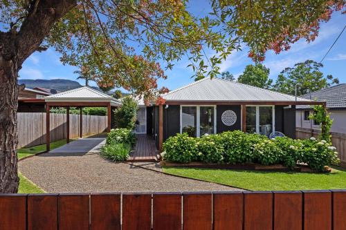 a house with a fence in front of it at Queenberry Cottage - Jacuzzi, Village Location & 10 Mins To Beach in Berry