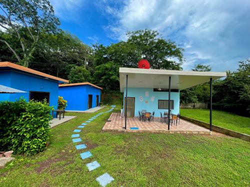a blue house with a pathway leading to it at POSADA MIRADIA in Matapalo