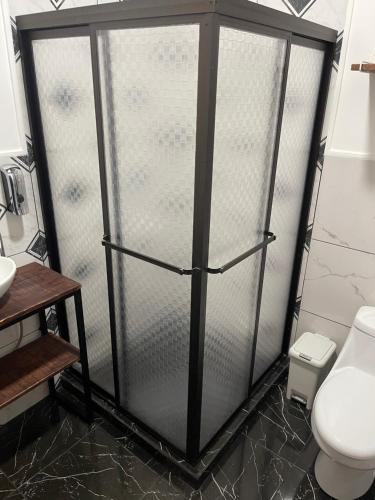 a shower stall in a bathroom with a toilet at POSADA MIRADIA in Matapalo