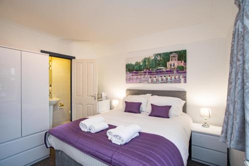 a bedroom with a bed with two towels on it at Wilson Lodge in Maidenhead