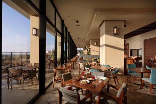 a restaurant with tables and chairs on a balcony at Hiyori Ocean Resort Okinawa in Onna