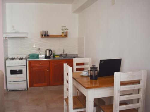 a kitchen with a wooden table and a stove at Ukiyo Apart in San Salvador de Jujuy
