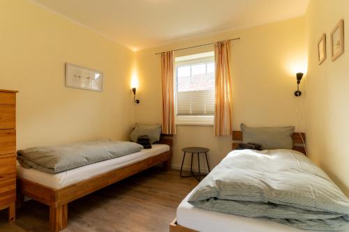 a bedroom with two twin beds and a window at FeWo Haus Friesenkind in Garding