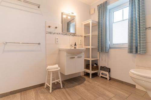 a bathroom with a sink and a toilet and a window at FeWo Haus Friesenkind in Garding