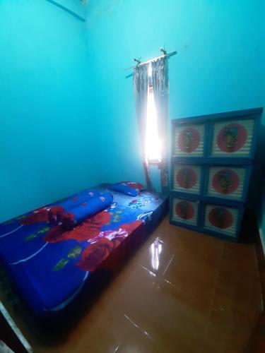 a bedroom with a bed and a blue light at D' Senayu in Masbagik