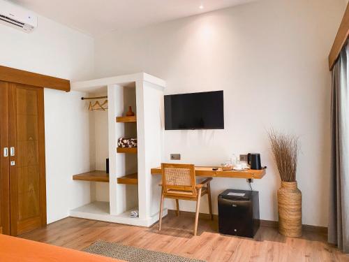 a room with a desk and a tv on a wall at Reset Lombok Hotel in Kuta Lombok