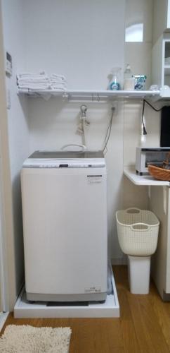 a small refrigerator in a kitchen with a sink at Yellow House in Naoshima