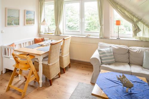 ein Wohnzimmer mit einem Tisch und einem Sofa in der Unterkunft FREESENHOFF Freesenhoff -OFDAK- in Langeoog