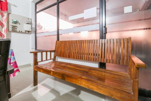 a wooden bench sitting in front of a window at SPOT ON Rohini Inn Kadampuzha in Kottakkal