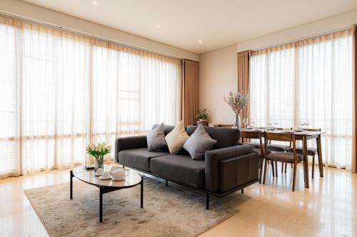 a living room with a black couch and a table at Park view Avalon Apartment District 1 HCM City in Ho Chi Minh City