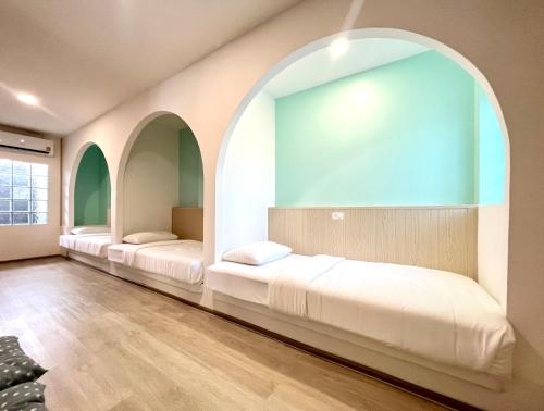 two beds in a room with an archway at SOVA Vcay Pool Villa in Ban Yai La