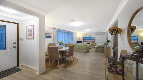 - une salle à manger et un salon avec une table et des chaises dans l'établissement Shore Fun - Ettalong Beach, à Ettalong Beach