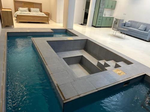 a pool of water in a room with a bed at مزون السحاب in Al Maghrafīyah