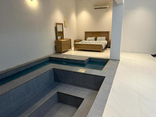 a room with a bed and a pool in the floor at مزون السحاب in Al Maghrafīyah