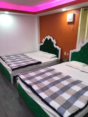 Un par de camas en un dormitorio con techo púrpura en KHÁCH SẠN BẢO AN en Ho Chi Minh