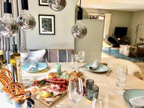 una mesa con un plato de comida y copas de vino en KitzMoments by Belle Stay en Reith bei Kitzbühel