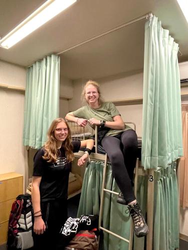 two women sitting on top of a bunk bed at Sakura Hotel Ikebukuro in Tokyo