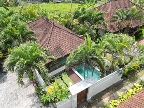 an aerial view of a house with a swimming pool and palm trees at Rumah Senang - Walk to Beach in Balian