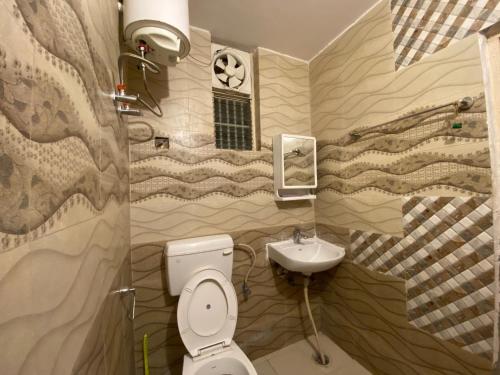 La salle de bains est pourvue de toilettes et d'un lavabo. dans l'établissement Kashi Karma Homestay, à Varanasi
