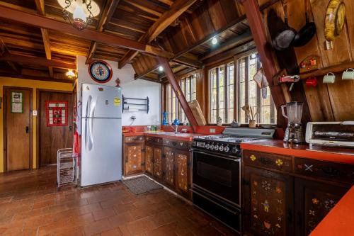 a kitchen with a white refrigerator and a stove at Chalet Lander Colonia Tovar in El Tigre