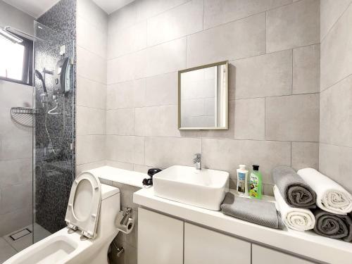 a bathroom with a sink and a toilet and a shower at The Shore Kota Kinabalu City Centre by LW Suites in Kota Kinabalu