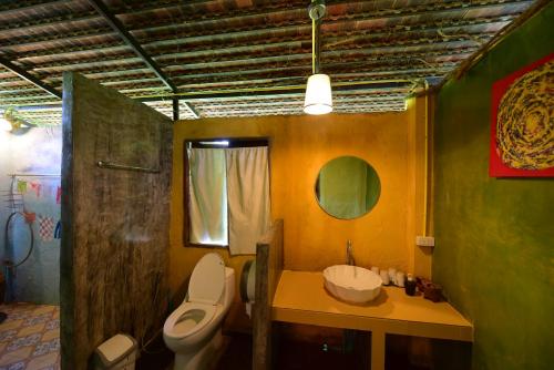 a bathroom with a toilet and a sink at อยู่ดินกินดีฟาร์มสเตย์ in Mae Rim