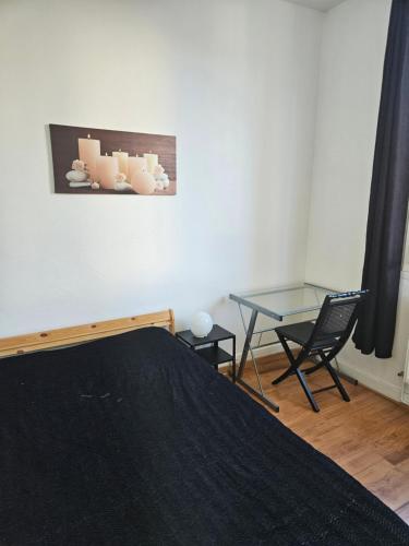 Un dormitorio con una cama y una mesa de cristal. en Appart T2 Quartier Beaujardin, en Tours