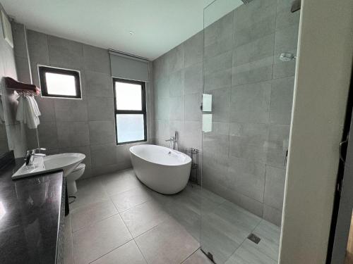 a bathroom with a tub and a sink at La Isla Pranburi Beach Resort in Sam Roi Yot