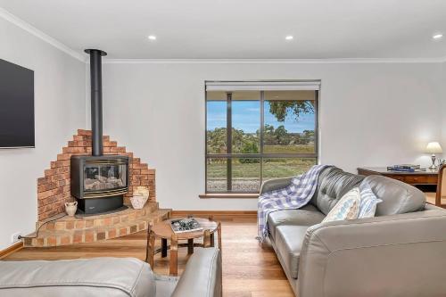 a living room with a couch and a fireplace at Picturesque Vineyard Farmhouse Nestled on 40-Acres in McLaren Vale