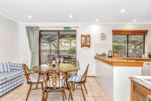 a kitchen and living room with a table and chairs at Picturesque Vineyard Farmhouse Nestled on 40-Acres in McLaren Vale
