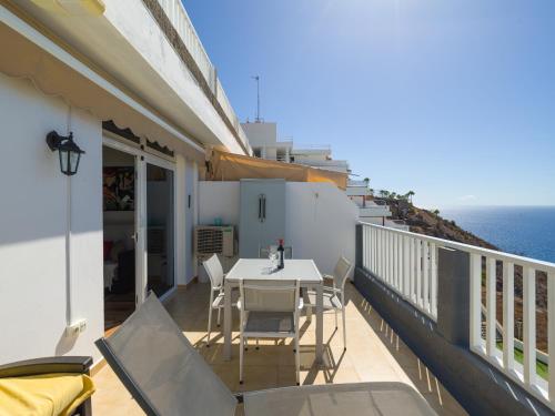 a balcony with a table and chairs and the ocean at Incredible Sunsets in Puerto Rico de Gran Canaria