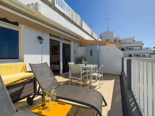 a patio with a table and chairs on a balcony at Incredible Sunsets in Puerto Rico de Gran Canaria