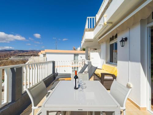 a white table with a bottle of wine on a balcony at Incredible Sunsets in Puerto Rico de Gran Canaria
