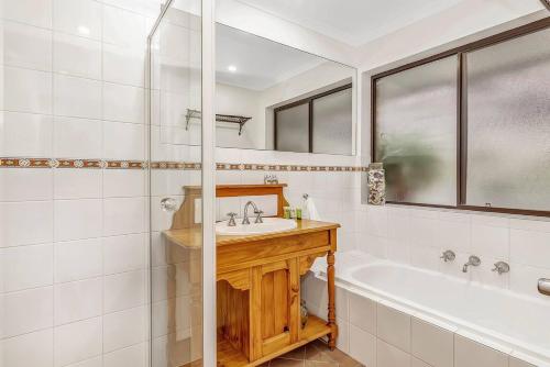 a bathroom with a tub and a sink and a shower at Picturesque Vineyard Farmhouse Nestled on 40-Acres in McLaren Vale