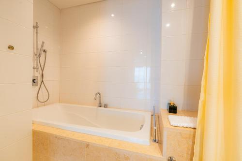 a white bath tub in a bathroom with a shower at Park view Avalon Apartment District 1 HCM City in Ho Chi Minh City