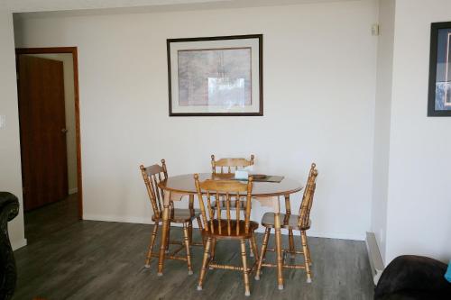 a dining room table with four chairs and a table at Ocean's Edge Suite in Campbell River