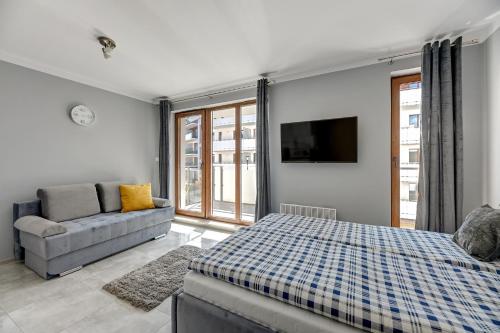 1 dormitorio con 1 cama y 1 sofá en STEGNA PARK B Apartamenty PIAMOLA en Stegna