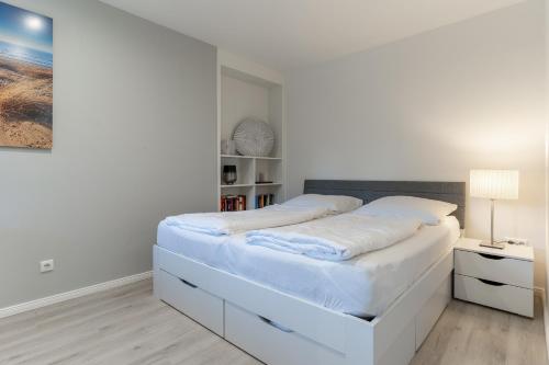 a white bedroom with a large white bed in it at Summer Diek Summerdiek 5 in Sankt Peter-Ording