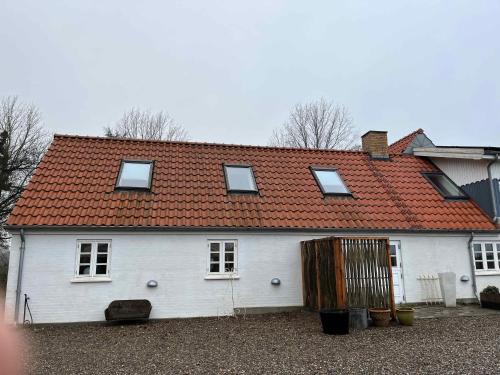Casa blanca con techo rojo en The Farm Guest House, en Svebølle