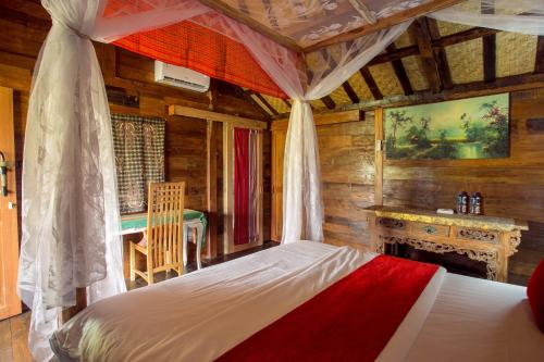 a bedroom with a bed and a table in a room at Pondok Cap Oleng Guesthouse Canggu by Ecommerceloka in Canggu