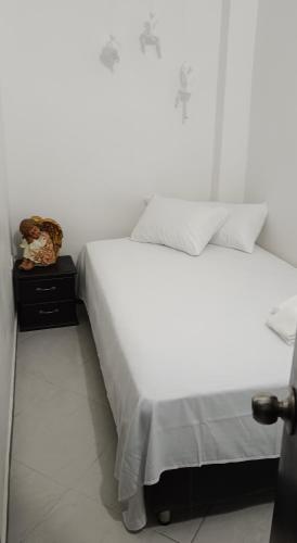 1 cama con sábanas blancas y almohadas en una habitación en Aparta Estudio en Puerto Berrio, en Puerto Berrío