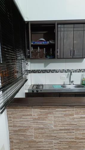 una cocina con armarios en blanco y negro y fregadero en Aparta Estudio en Puerto Berrio, en Puerto Berrío