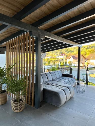 a large couch sitting under a pergola on a patio at Pensiunea White Department in Vlădeşti