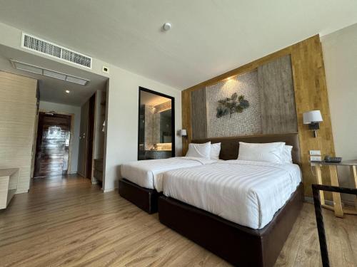 a bedroom with a large bed with white sheets at La Isla Pranburi Beach Resort in Sam Roi Yot