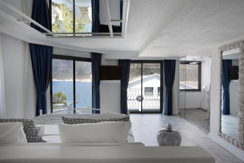 a living room with a couch and some windows at Alley Prime Hotel in Kaş